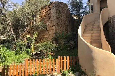 a wooden fence in front of a brick building with stairs at Villa Solsticia in Porticcio