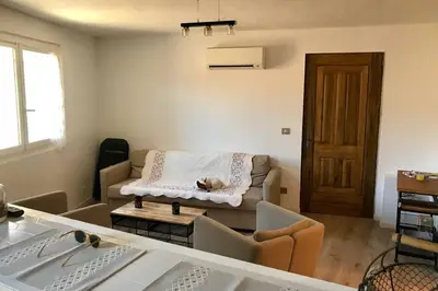 a living room with a couch with a blanket on it at Villa Solsticia in Porticcio
