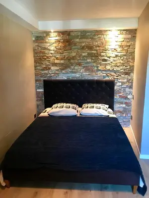 a bed in a room with a brick wall at Villa Solsticia in Porticcio