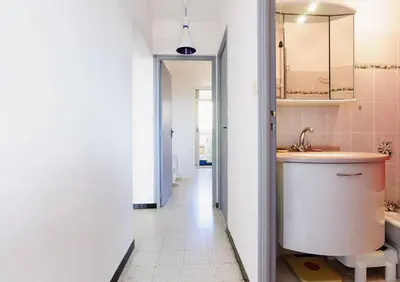 a bathroom with a sink and a toilet and a hallway at Bel Orizonte, Grand appart 70m2 vue mer in Ajaccio