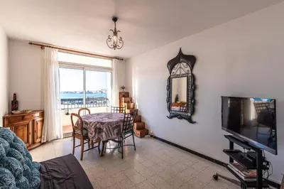 a living room with a table and a television at Bel Orizonte, Grand appart 70m2 vue mer in Ajaccio