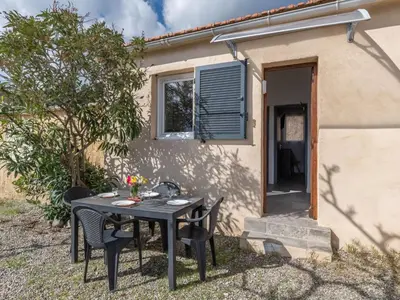 a table and chairs in front of a house at Holiday Home Mustella by Interhome in Sari Solenzara
