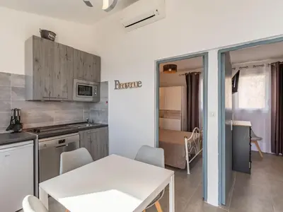 a kitchen with a white table and a dining room at Holiday Home Mustella by Interhome in Sari Solenzara