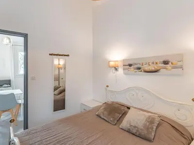 a bedroom with a bed and a table and a mirror at Holiday Home Mustella by Interhome in Sari Solenzara