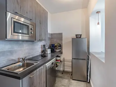 a kitchen with a sink and a stainless steel refrigerator at Holiday Home Scorpina by Interhome in Sari Solenzara