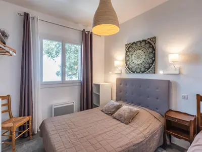 a bedroom with a bed and a window at Holiday Home Scorpina by Interhome in Sari Solenzara