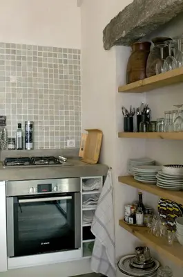 a kitchen with a stove and a counter with plates at Domaine de Peretti della Rocca in Figari