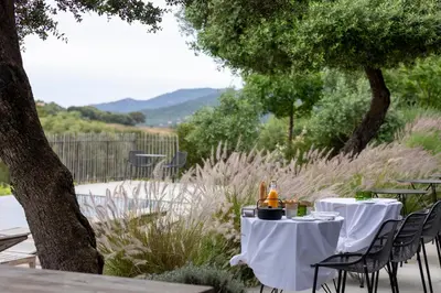 a table with white table cloths and a tea kettle on it at Domaine de Peretti della Rocca in Figari