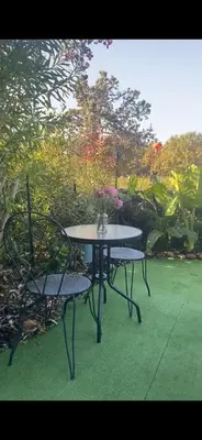 a table with two chairs and a table with flowers on it at Les pieds dans l eau de Betty Ghisonaccia plage 50 m in Ghisonaccia