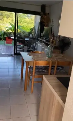 a dining room with a table and chairs and a television at Les pieds dans l eau de Betty Ghisonaccia plage 50 m in Ghisonaccia