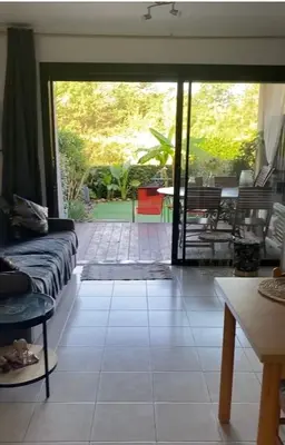 a living room with a couch and a patio at Les pieds dans l eau de Betty Ghisonaccia plage 50 m in Ghisonaccia