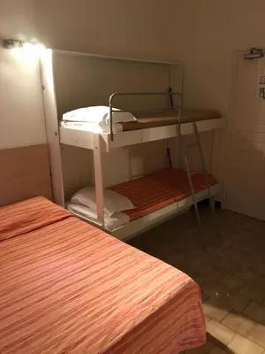 a room with two bunk beds and a bed at Hôtel Colombo- Porto Corse in Porto Ota