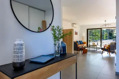a living room with a mirror on the wall at Calarossa Bay Resort in Porto-Vecchio