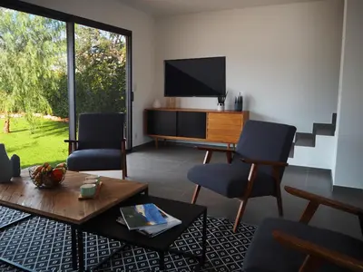 a living room with two chairs and a television at Calarossa Bay Resort in Porto-Vecchio