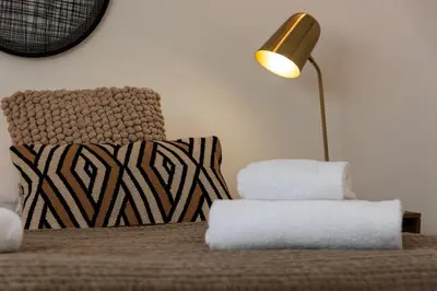 a bedroom with a bed with a lamp and a chair at Calarossa Bay Resort in Porto-Vecchio
