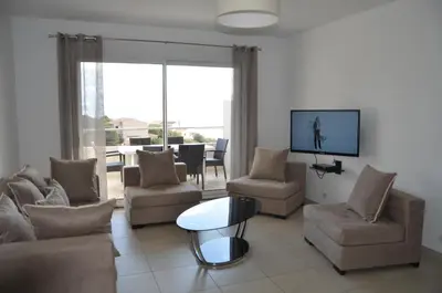 a living room with a couch and chairs and a tv at Résidence Giovanello in Porto Pollo