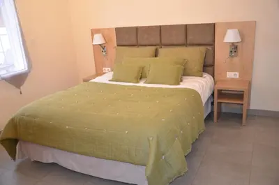 a bedroom with a large bed with green sheets and pillows at Résidence Giovanello in Porto Pollo
