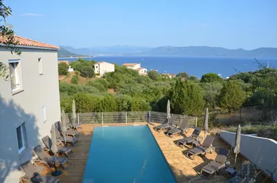 a swimming pool with lounge chairs and a house at Résidence Giovanello in Porto Pollo