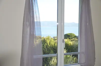 a window with a view of the ocean at Résidence Giovanello in Porto Pollo