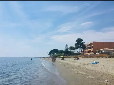 a group of people on a beach near the water at Residence Santa Lucia, studio avec piscine , vue mer et pied dans l'eau , Moriani-Plage in Santa-Lucia-di-Moriani