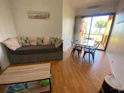 a living room with a couch and a table at Residence Santa Lucia, studio avec piscine , vue mer et pied dans l'eau , Moriani-Plage in Santa-Lucia-di-Moriani