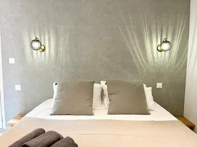 a bedroom with a bed with two lights on the wall at Domaine de Licetto in Bonifacio