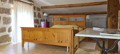 a bedroom with a wooden bed and a table at L'Orca di San Gavinu in Figari