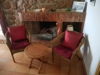 a living room with two chairs and a fireplace at L'Orca di San Gavinu in Figari