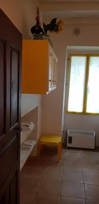a room with a yellow stool and a window at L'Orca di San Gavinu in Figari