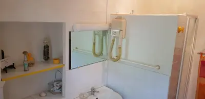 a small bathroom with a sink and a refrigerator at L'Orca di San Gavinu in Figari