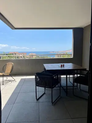 a table and chairs in a room with a large window at T2 Ajaccio vue mer in Ajaccio