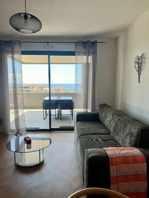 a living room with a couch and a table at T2 Ajaccio vue mer in Ajaccio