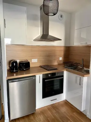 a kitchen with white cabinets and a stove top oven at T2 Ajaccio vue mer in Ajaccio