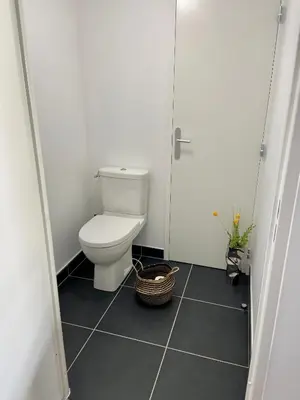a small bathroom with a toilet and a door at T2 Ajaccio vue mer in Ajaccio
