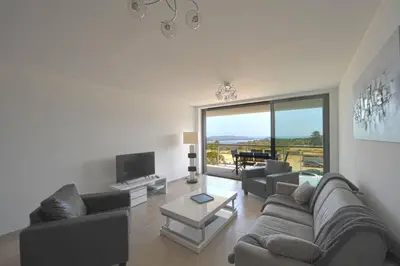 a living room with a couch and a table at Bel appartement vue mer Porto Vecchio in Porto-Vecchio