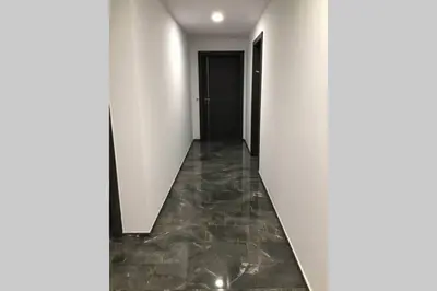 a hallway with white walls and a black door at Bel appartement vue mer Porto Vecchio in Porto-Vecchio