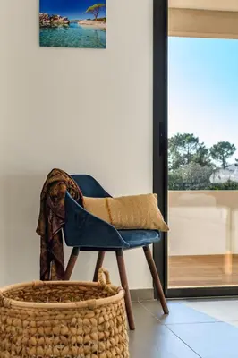 a blue chair sitting in a room with a basket at Hotel Calarossa Bay Resort in Porto-Vecchio