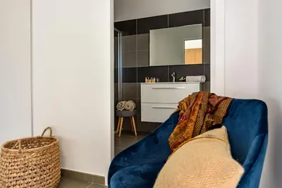 a living room with a blue couch and a mirror at Hotel Calarossa Bay Resort in Porto-Vecchio