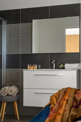 a bathroom with a sink and a stool and a mirror at Hotel Calarossa Bay Resort in Porto-Vecchio