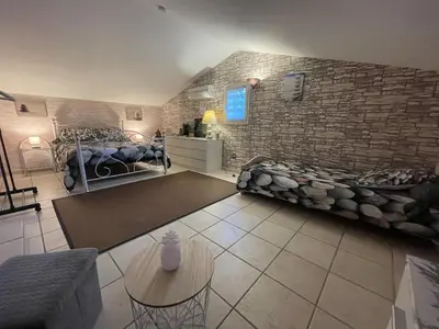 a room with two beds and a brick wall at Chez Chris Mare & Macchia in Porto-Vecchio