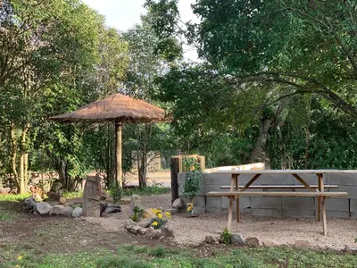 a picnic table and an umbrella in a park at Chez Chris Mare & Macchia in Porto-Vecchio