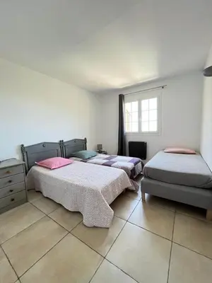 a bedroom with two beds and a window at Maison 4 Pers - Vue mer et vignoble exceptionnelle in Poggio-dʼOletta