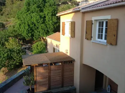 an external view of a building with a wooden gate at Maison 4 Pers - Vue mer et vignoble exceptionnelle in Poggio-dʼOletta