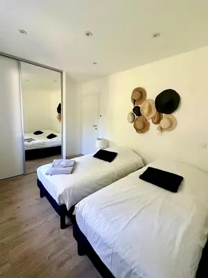 two beds in a room with a mirror at VILLA JUWEN in Oletta