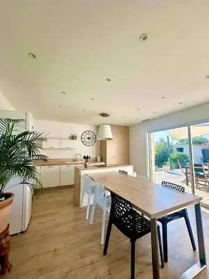 a kitchen and dining room with a wooden table and chairs at VILLA JUWEN in Oletta