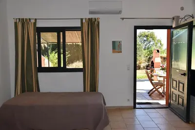 a bedroom with a bed and a sliding glass door at Terracorse in Figari