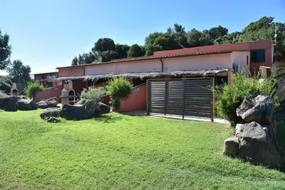 a building with a garage in a yard with rocks at Terracorse in Figari