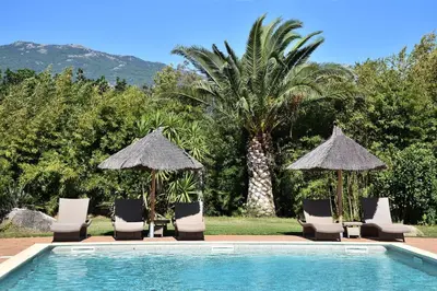 a group of chairs and umbrellas next to a pool at Terracorse in Figari
