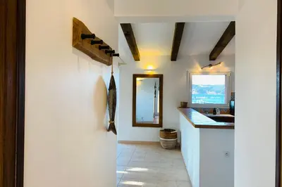 a bathroom with a sink and a mirror at Charmante villa 2 chambres les pieds dans l'eau Bonifacio in Bonifacio