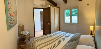 a small bedroom with a bed and a window at Charmante villa 2 chambres les pieds dans l'eau Bonifacio in Bonifacio